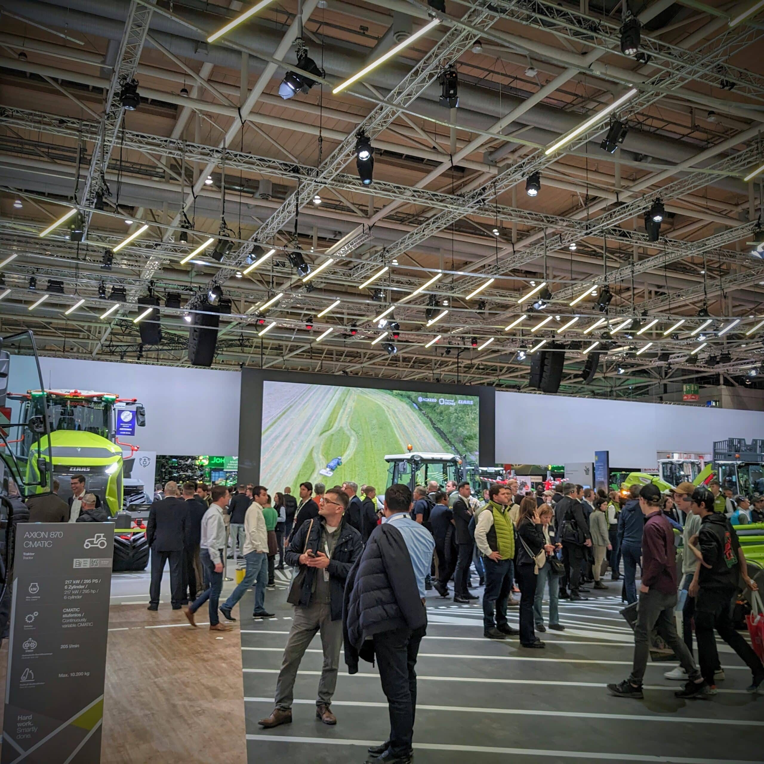 Bild einer Ansammlung von Menschen auf der Agritechnica-Messe. Im Hintergrund ist der Messestand von Claas zu sehen.